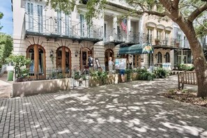 A historic building with arched doorways, a balcony, and a flag. - After Dune Delight Condo with Pools & Tennis (Santa Rosa Beach)
