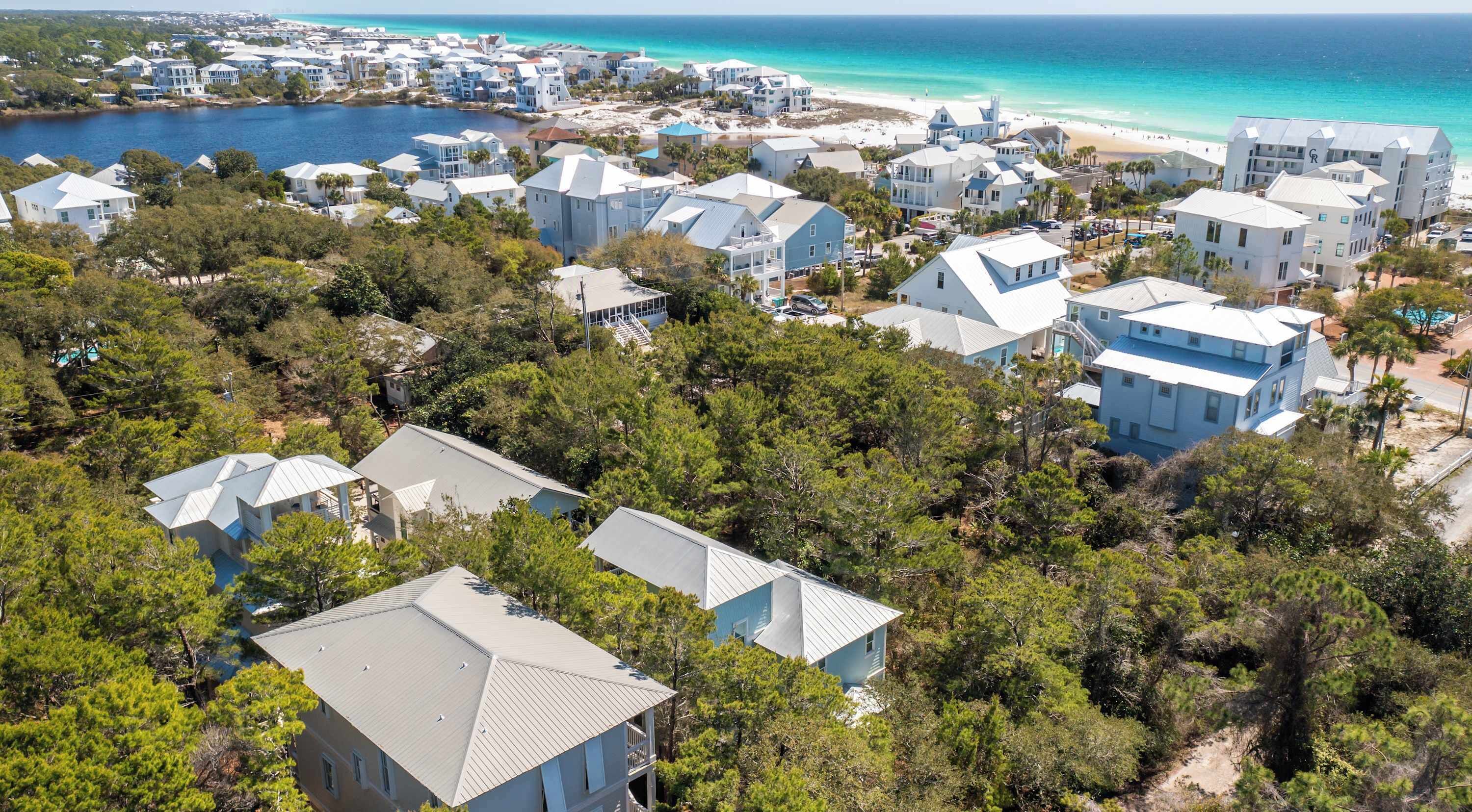 A coastal residential area with houses, a beach, and a body of water.