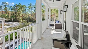 A covered balcony with a pool, white railings, and outdoor seating. - Santa Rosa Home with Private Pool, Near Beach (Santa Rosa Beach)