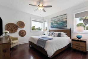 A bedroom with a bed, bedside tables, a ceiling fan, artwork, and a window with a view. - Inlet Beach Home with Shared Pool, Cart & Bikes (Inlet Beach)