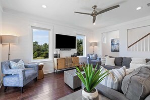A modern living room with a flat-screen TV, two sofas, a coffee table, and a ceiling fan. - Inlet Beach Home with Shared Pool, Cart & Bikes (Inlet Beach)