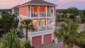 Une maison à deux étages avec un balcon, un garage et une vue sur le quartier environnant.