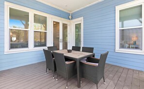 A covered patio with a table and chairs, large windows, and a door. - Seacrest Home with Pool & Private Beach Access (Rosemary Beach)