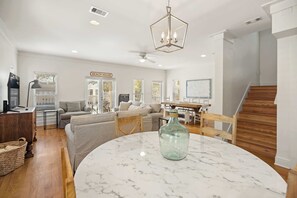 A spacious living room with a marble table, a sofa, and a dining area. - Gulf-View Home with Deeded Beach & Pool, Seacrest (Seacrest)
