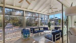 A covered outdoor area with a sofa, chairs, and a table. - Vitamin Sea Home with Golf Cart & Shared Pool (Watersound)