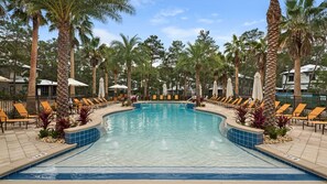 A swimming pool with lounge chairs and palm trees. - Vitamin Sea Home with Golf Cart & Shared Pool (Watersound)