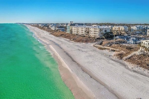 Ein Hotel an der Küste mit direktem Strandzugang, mehreren Gebäuden und einem Sandstrand.