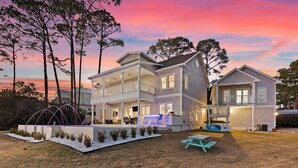 A two-story house with a covered patio, a swimming pool, and a small deck area. - Oyster Lake Estate with Pool, Dock & Golf Cart (Santa Rosa Beach)