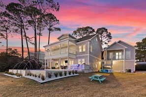 A two-story house with a covered patio, a swimming pool, and a small deck area. - Oyster Lake Estate with Pool, Dock & Golf Cart (Santa Rosa Beach)