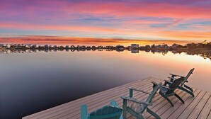 A waterfront view with a wooden dock and two Adirondack chairs. - Oyster Lake Estate with Pool, Dock & Golf Cart (Santa Rosa Beach)