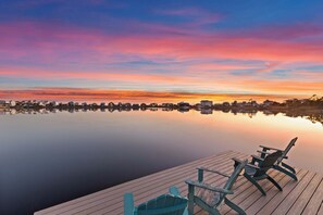 A waterfront view with a wooden dock and two Adirondack chairs. - Oyster Lake Estate with Pool, Dock & Golf Cart (Santa Rosa Beach)