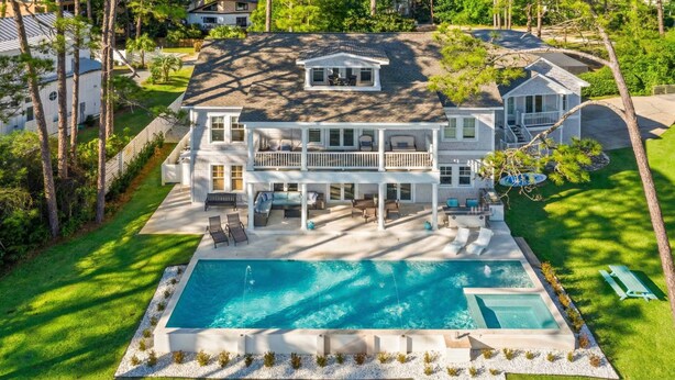A large two-story house with a swimming pool, outdoor seating, and a well-maintained lawn. - Oyster Lake Estate with Pool, Dock & Golf Cart (Santa Rosa Beach)