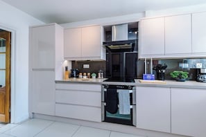 Eine moderne Küche mit weißen Schränken, einem eingebauten Backofen und einem Geschirrspüler.