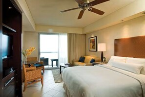 A hotel room with a bed, a desk, a chair, a sofa, a ceiling fan, and a window. - Westin Lagunamar 2 Bedroom Villa with Balcony (Cancun)