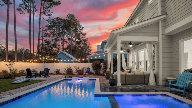 A swimming pool with lounge chairs and a covered patio area. - Sea Change Home with Pool, Lake Access & Golf Cart (Santa Rosa Beach)