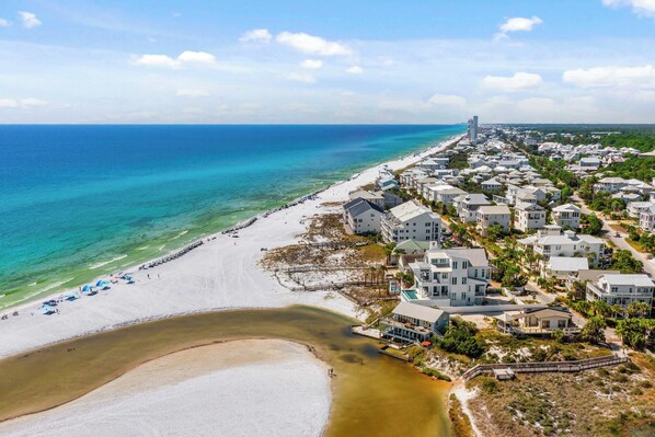 Eine Küstenlandschaft mit Strand, Strandhäusern und einem weiter entfernten Turm.