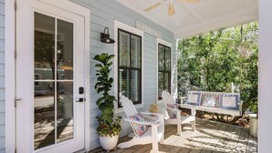 A porch with two Adirondack chairs, a bench, and a potted plant. - Seagrove Home for Groups, Near 30A Beach & Pool (Santa Rosa Beach)