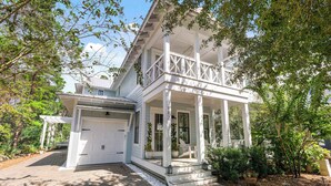 A two-story house with a covered porch, a garage, and a well-maintained garden. - Seagrove Home for Groups, Near 30A Beach & Pool (Santa Rosa Beach)