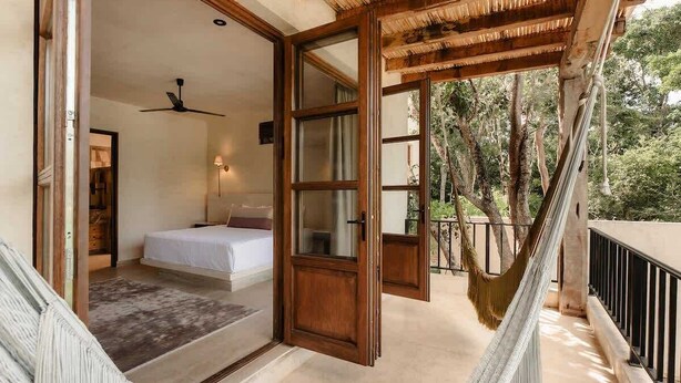 A bedroom with a bed, a ceiling fan, and a view of the outdoors. - Rooftop Steam Spa, Private Pool & Jungle Retreat (Tulum)