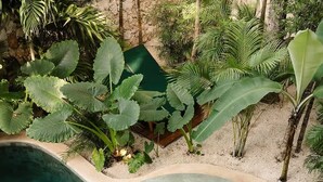 A circular hot tub surrounded by lush tropical plants and a swimming pool. - Rooftop Steam Spa, Private Pool & Jungle Retreat (Tulum)