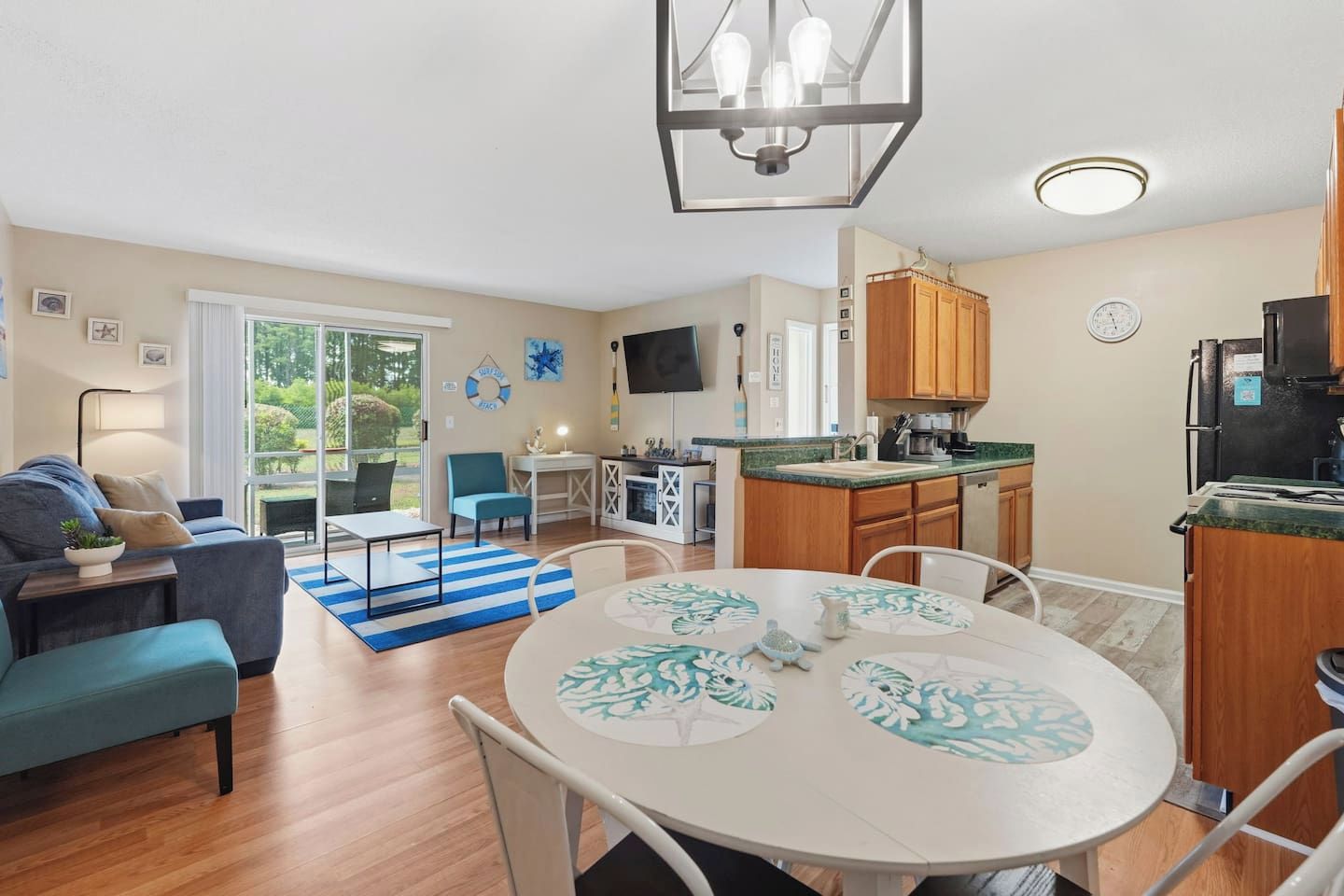 A modern apartment with a living room, dining area, kitchen, and a balcony with a view.