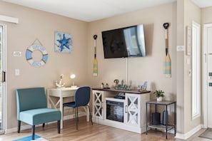Ein Wohnzimmer mit Fernseher, einem Schild für einen Strandabschnitt und einem Stand-Up-Paddleboard.