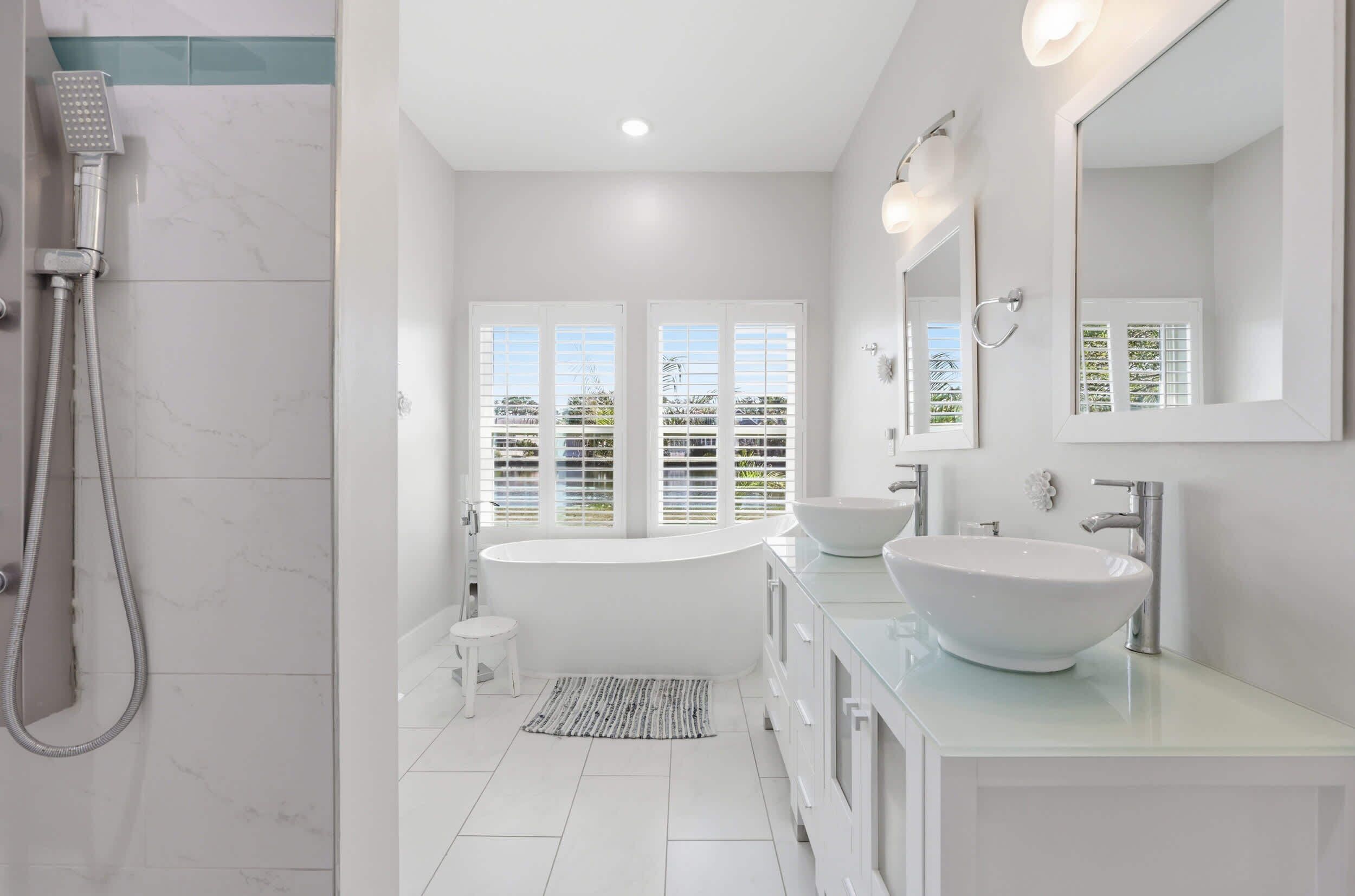 A modern bathroom with a freestanding bathtub, a large mirror, and a walk-in shower.