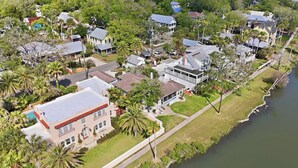 An aerial view of a residential area with houses, a river, and a well-maintained lawn. - Morning Glory - Historic Downtown (St. Augustine)