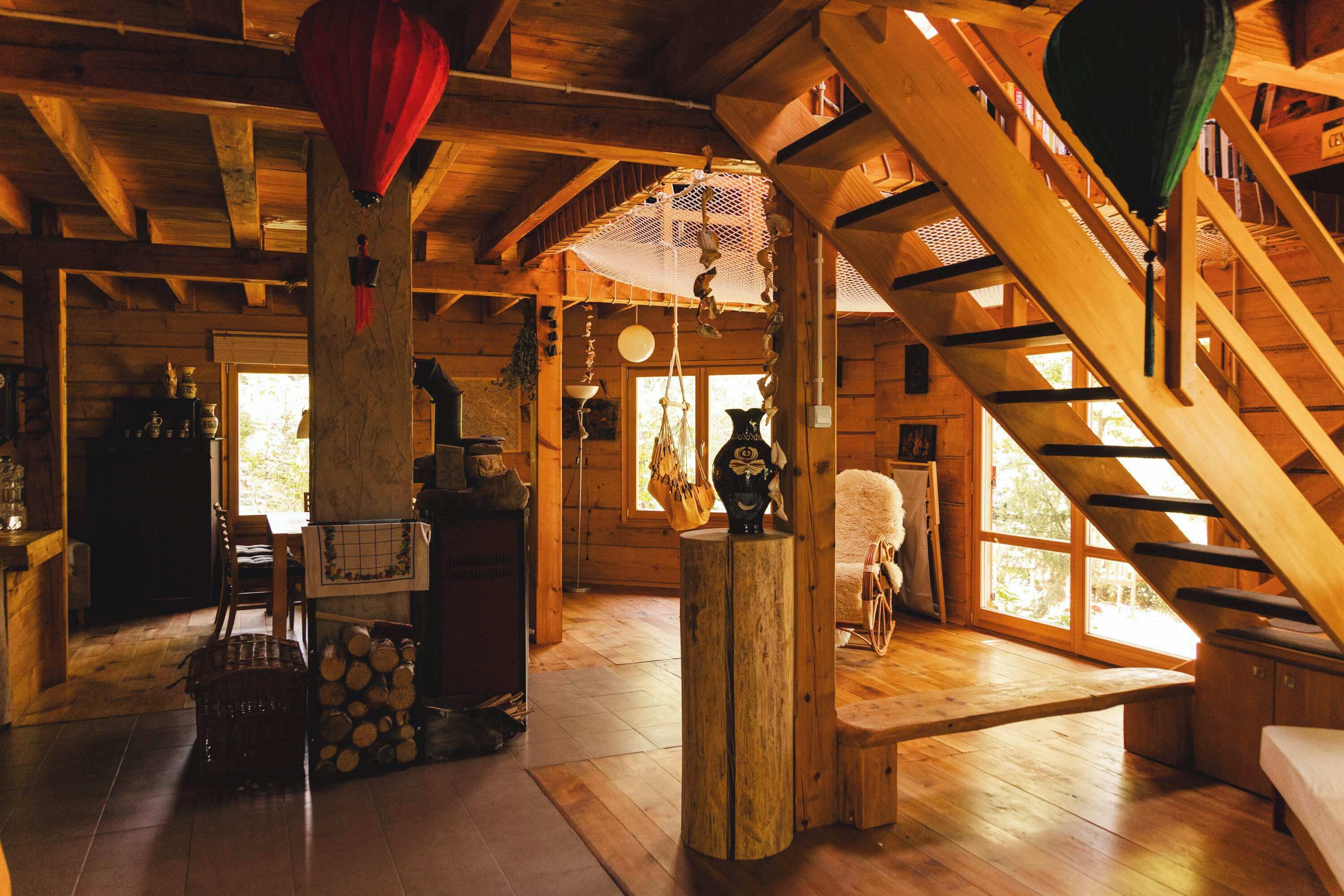 Puinen sisustus, jossa on portaikko, puupalkit ja maalaishenkinen ilme.
