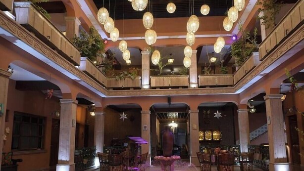 A hotel lobby with a central atrium, multiple levels, and hanging lanterns. - Hotel Posada del Balsas  (Apatzingan)