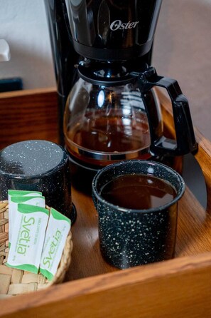 A coffee maker, a glass carafe, and two cups on a wooden tray. - Hotel Posada del Balsas  (Apatzingan)