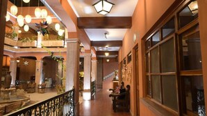 A hotel corridor with a wooden floor, a wrought iron railing, and a staircase leading to an upper level. - Hotel Posada del Balsas  (Apatzingan)