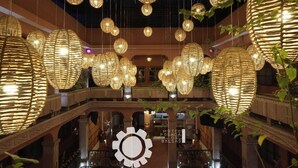 A hotel interior with multiple levels, ornate railings, and hanging spherical light fixtures. - Hotel Posada del Balsas  (Apatzingan)