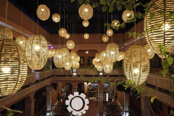 A hotel interior with multiple levels, ornate railings, and hanging spherical light fixtures. - Hotel Posada del Balsas  (Apatzingan)