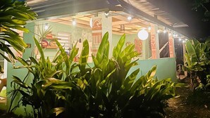A building with a covered outdoor area, surrounded by greenery. - La Casita - Glamping bungalow with AC in Rincón (Rincón)