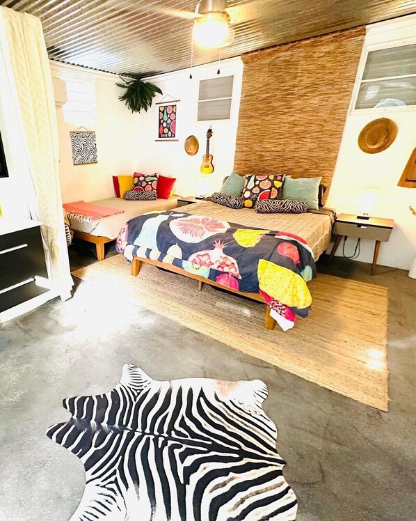 A bedroom with a bed, a guitar, and a zebra-patterned pillow. - La Casita - Glamping bungalow with AC in Rincón (Rincón)