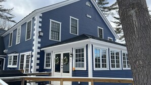 Kaksikerroksinen talo, jossa on katettu kuisti ja autotalli.