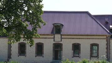 A building with a brick facade, a central entrance, and a metal roof.