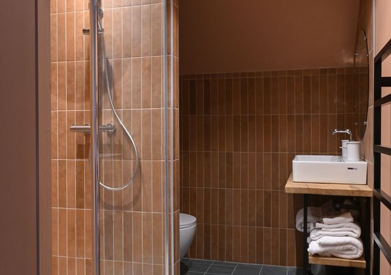 Une salle de bain avec douche, toilettes et un lavabo avec des serviettes.