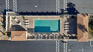 An aerial view of a hotel with a swimming pool, sun loungers, and a parking lot. - Sugar Beach F-28 ~ Gulf-side luxury townhome! (Navarre)