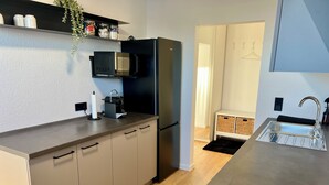 Eine moderne Küche mit integriertem Mikrowellenherd, Kühlschrank, Spüle und einer Arbeitsplatte.
