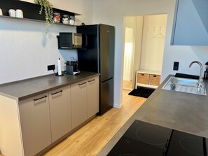Eine moderne Küche mit integriertem Mikrowellenherd, Kühlschrank, Spüle und einer Arbeitsplatte.