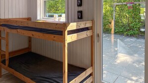 A bunk bed with a window, a door, and a view of a garden. - 2 bedroom lovely home in Thyholm (Thyholm)