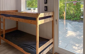 Ein Stockbett mit Fenster, Tür und Blick auf einen Garten.