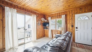 En interiör med träpanel, en soffa, en dörr och ett fönster.