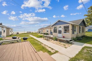 A beachfront mobile home with a deck, barbecue grill, and a view of the beach. - #8 | Spacious & Quiet Near the Sand (Oscoda)