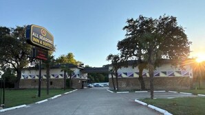 A hotel entrance with a sign for 'All Seasons Inn & Suites' and a parking area. - All Season Suites Inn  (Dallas)