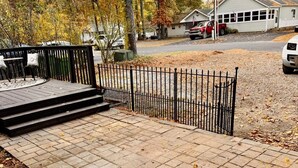 A paved walkway leading to a building with a metal fence, surrounded by trees with autumn foliage. - 3-bedroom house Near Masssy's boat ramp, Paradise Grill & Pot N Nets & Baywood (Millsboro)