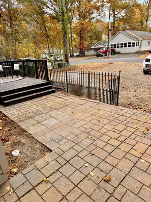A paved walkway leading to a building with a metal fence, surrounded by trees with autumn foliage. - 3-bedroom house Near Masssy's boat ramp, Paradise Grill & Pot N Nets & Baywood (Millsboro)
