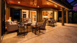 An outdoor living area with furniture, a ceiling fan, and a view of the interior.